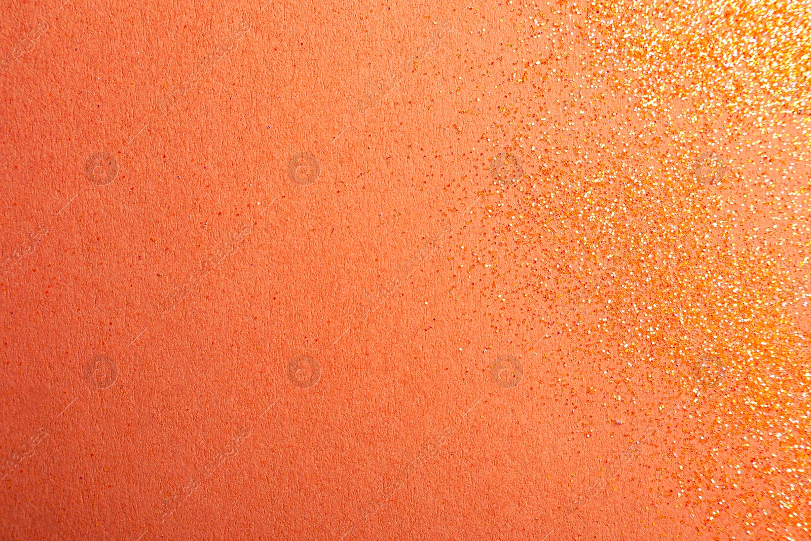 Photo of Shiny bright glitter on coral background, flat lay. Space for text