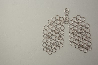 Human lungs made of metal rings on grey textured table, flat lay. Space for text