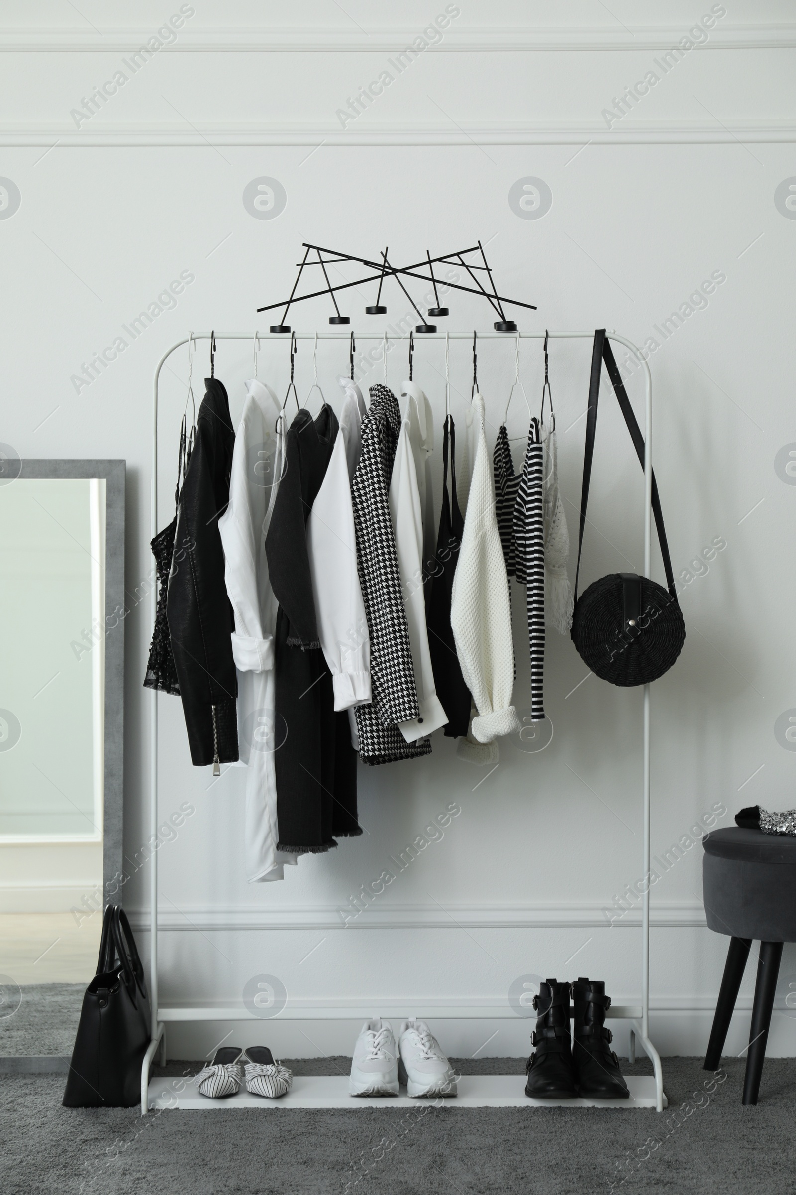 Photo of Rack with stylish clothes in modern dressing room