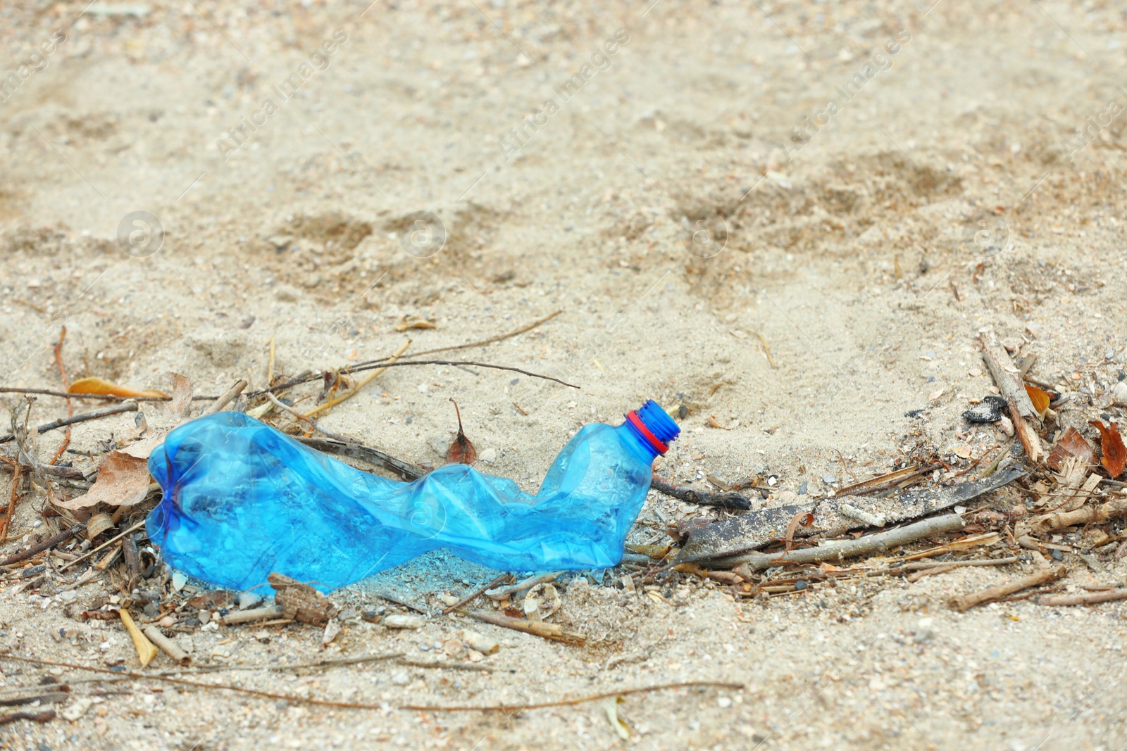 Photo of Used plastic bottle on beach, space for text. Recycling problem