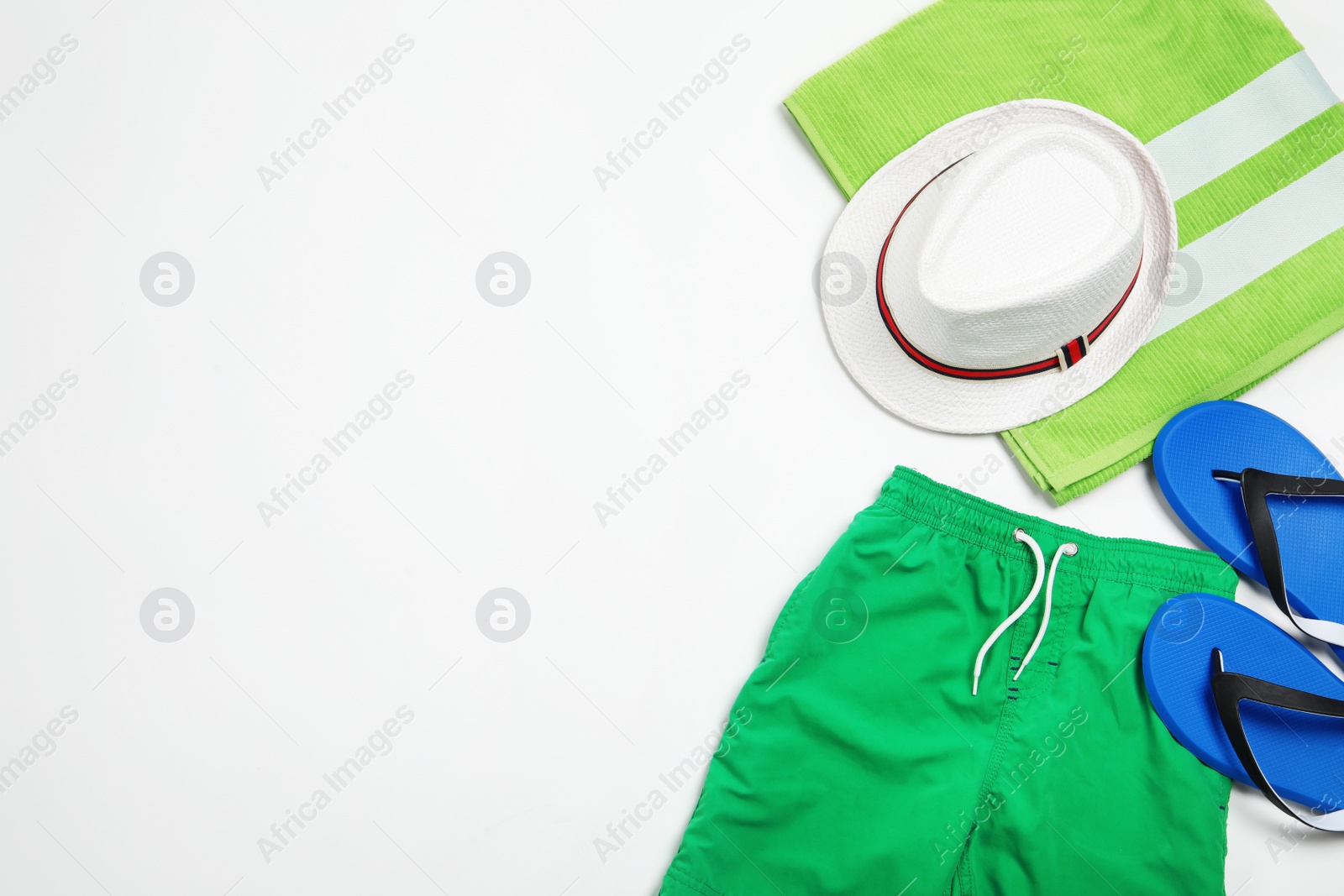 Photo of Flat lay composition with stylish male swim trunks on white background, space for text. Beach objects