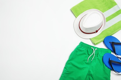 Photo of Flat lay composition with stylish male swim trunks on white background, space for text. Beach objects