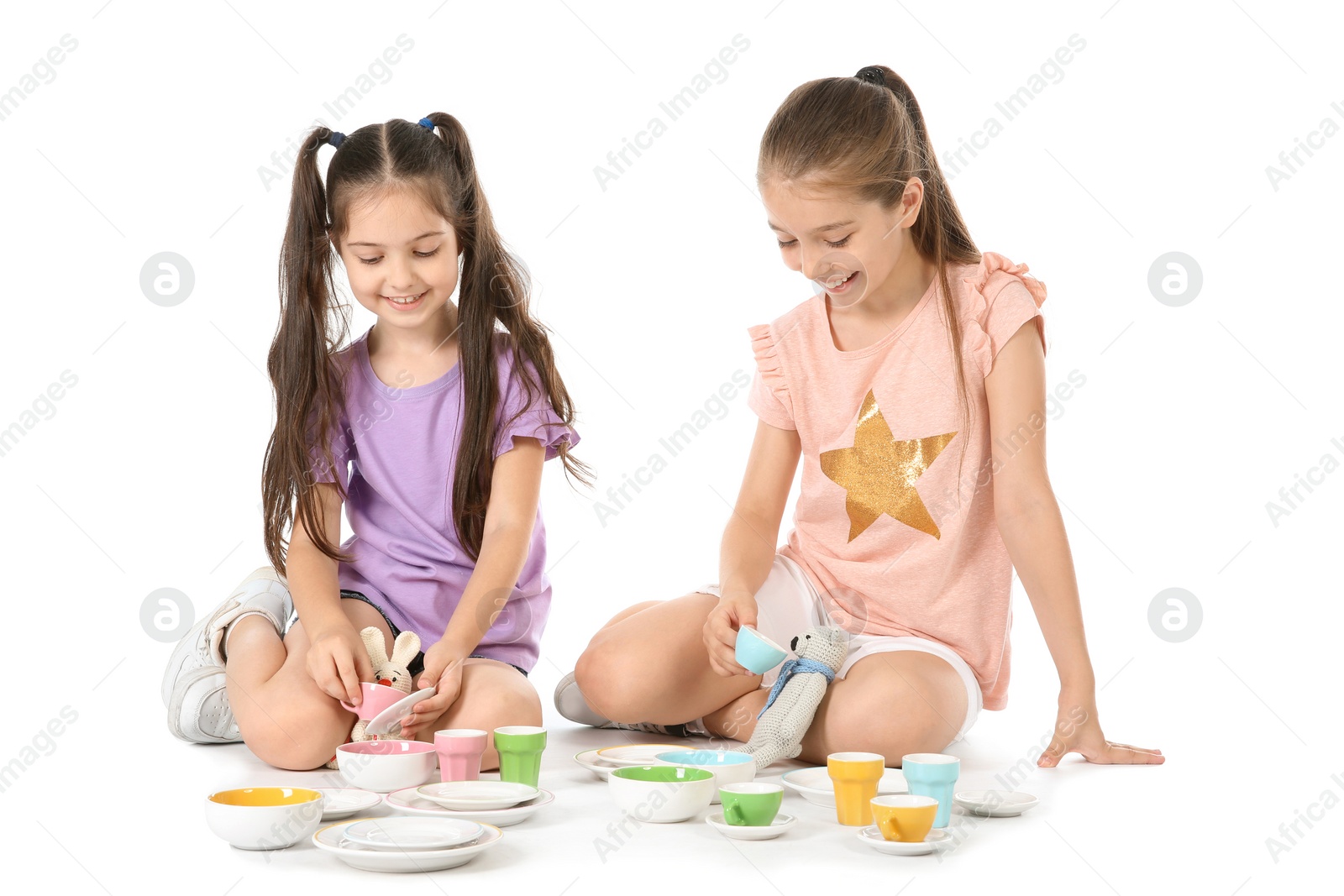 Photo of Little children playing tea party with toys on white background. Indoor entertainment