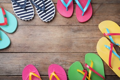 Many different flip flops on wooden background, flat lay. Space for text