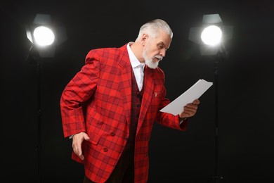 Photo of Senior actor with script performing on stage