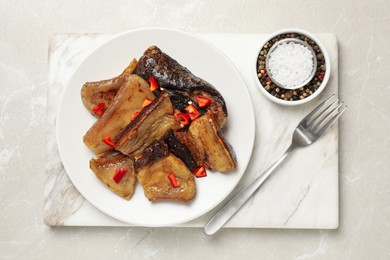 Photo of Tasty fried pork lard with pepper on light table, top view