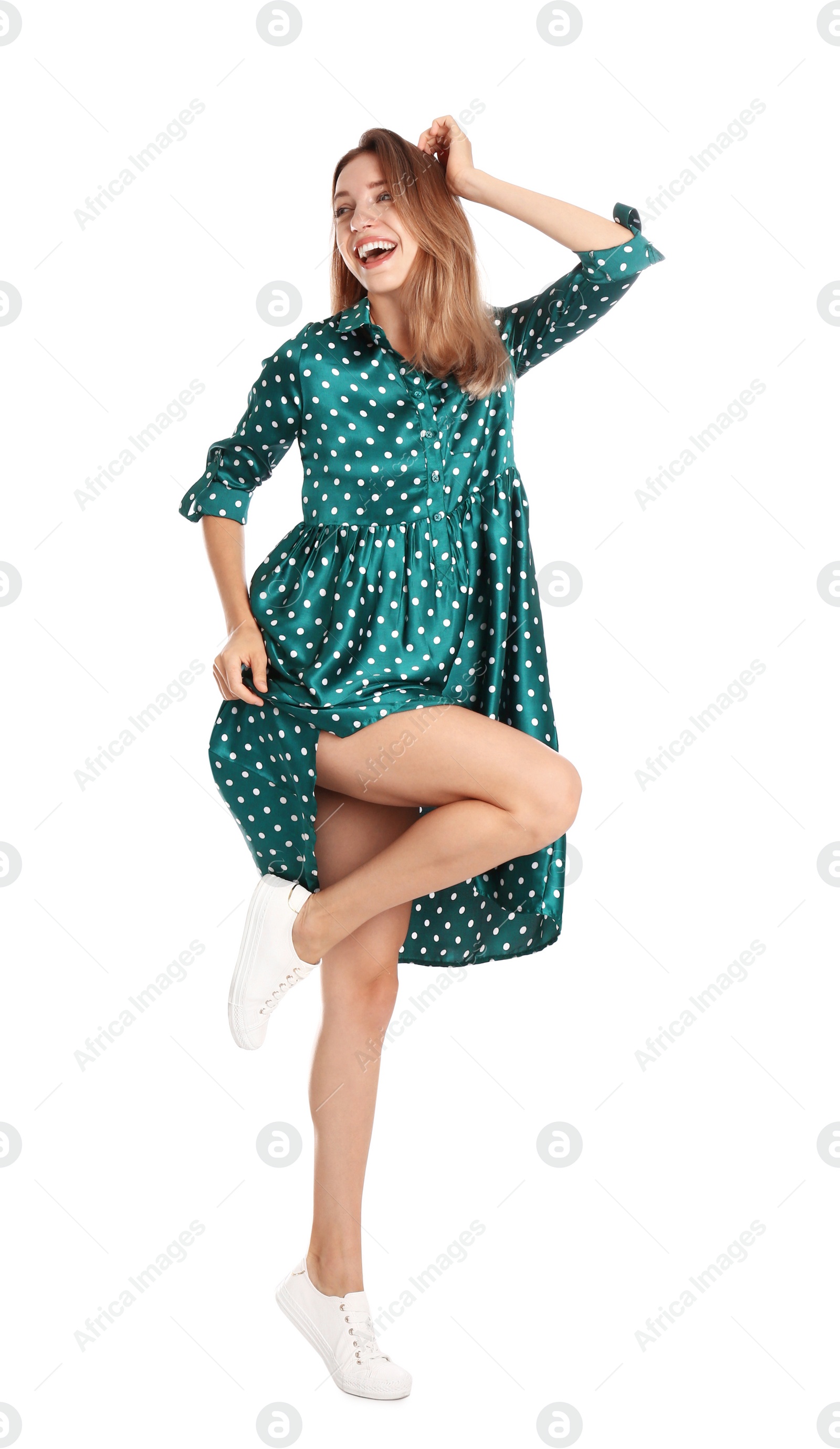 Photo of Beautiful young woman in green dress dancing on white background