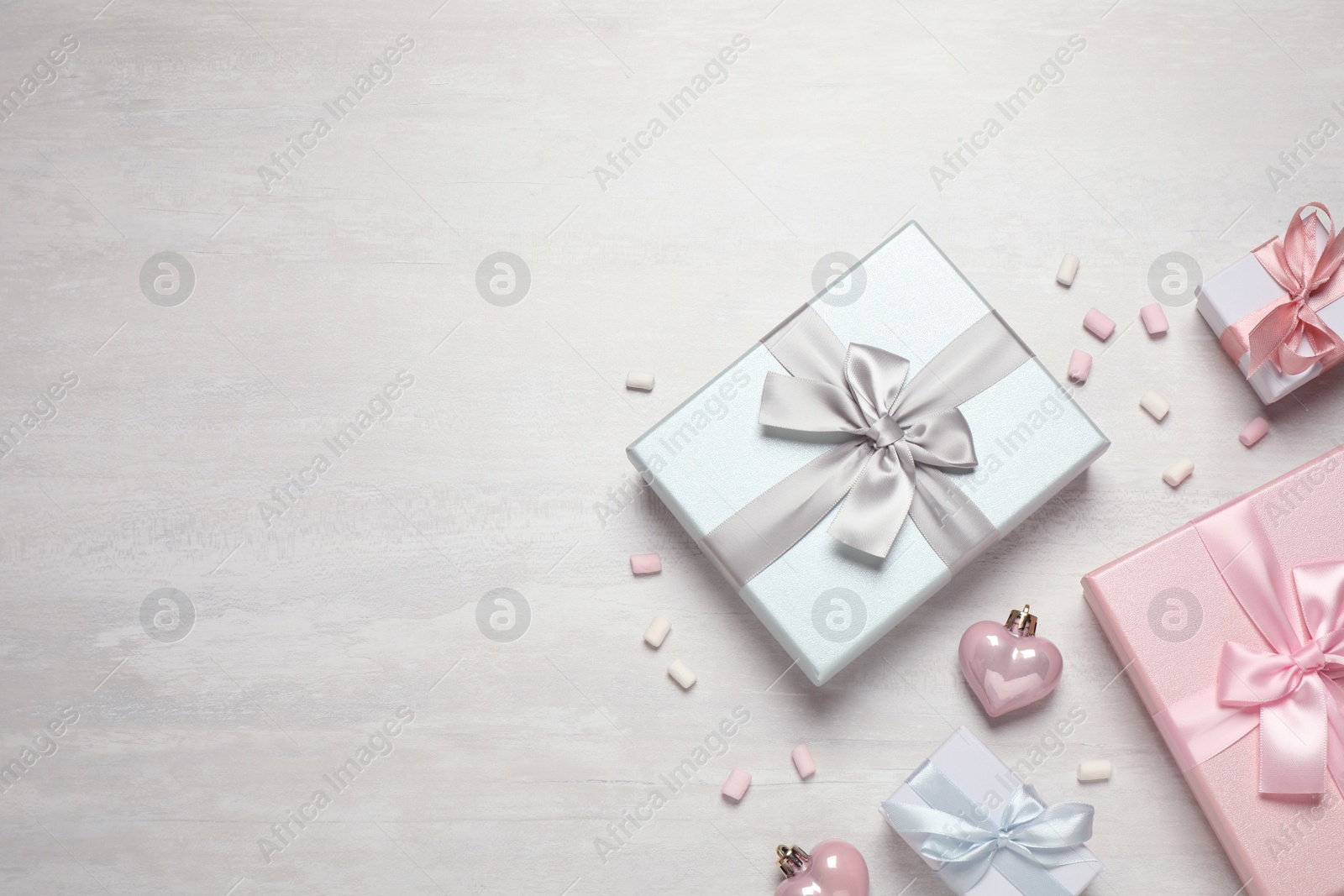 Photo of Beautiful gift boxes and festive decor on white table, flat lay. Space for text