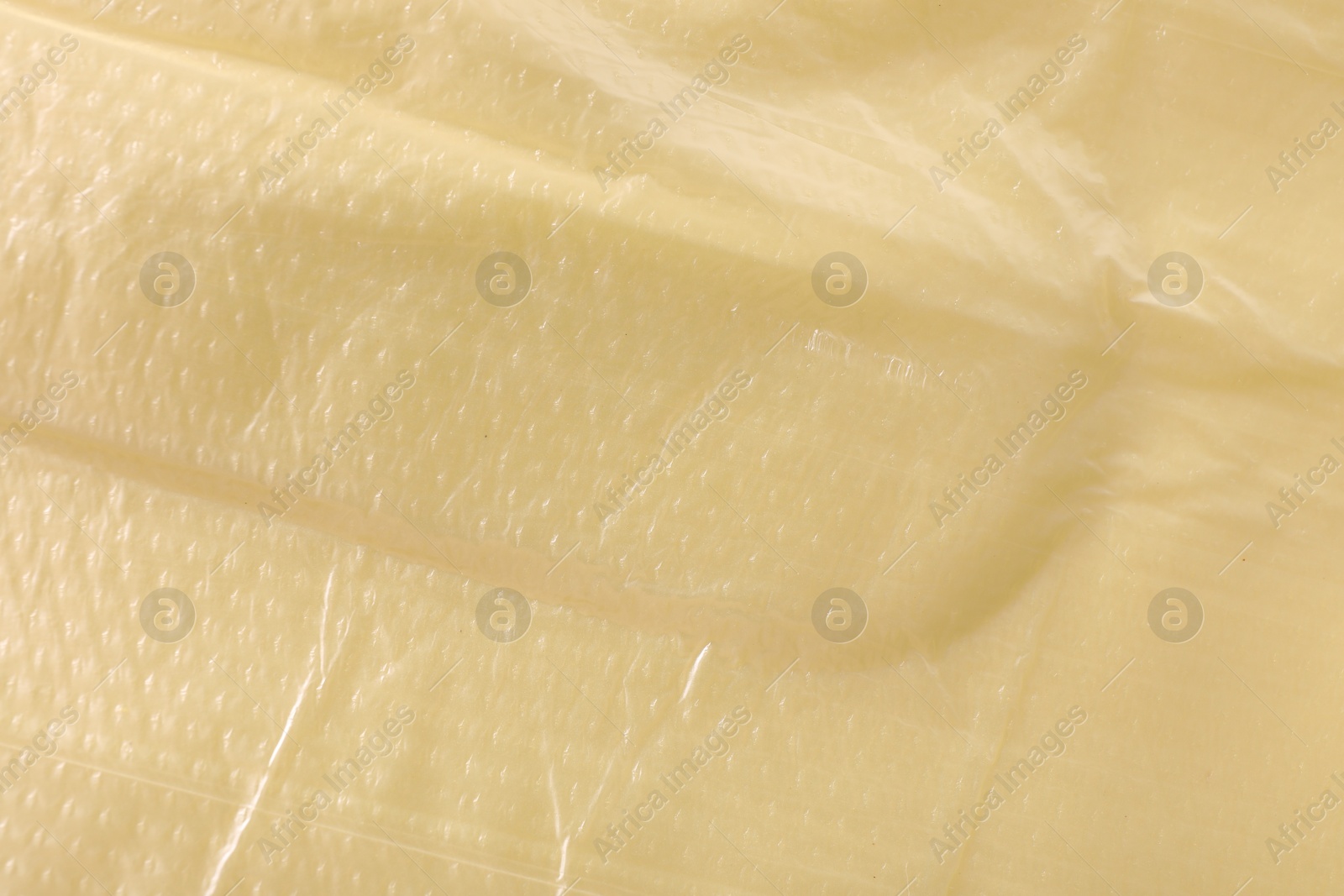 Photo of Texture of yellow plastic bag as background, closeup