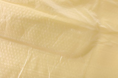 Texture of yellow plastic bag as background, closeup