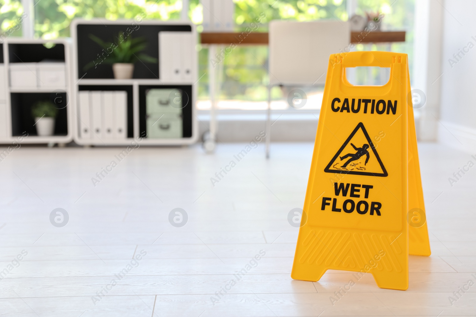 Photo of Safety sign with phrase "CAUTION WET FLOOR", indoors