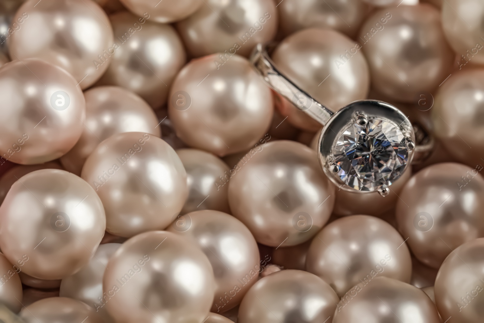Photo of Beautiful decor pearls and engagement ring, closeup. Space for text