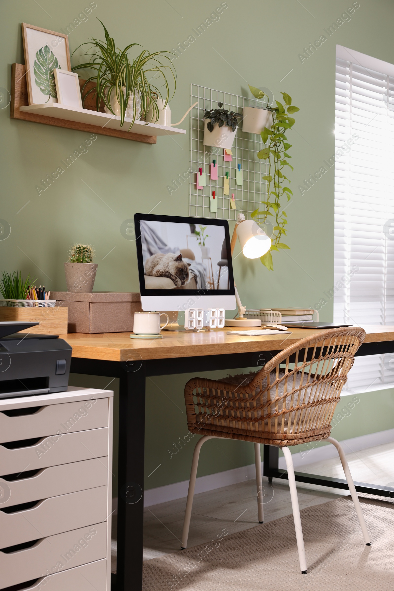 Photo of Stylish workplace with computer, laptop and lamp near olive wall at home