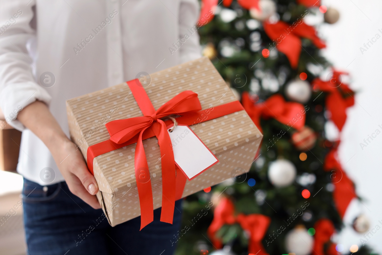 Photo of Young woman with Christmas gift at home