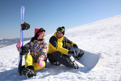 Photo of Couple with snowboards on hill. Winter vacation