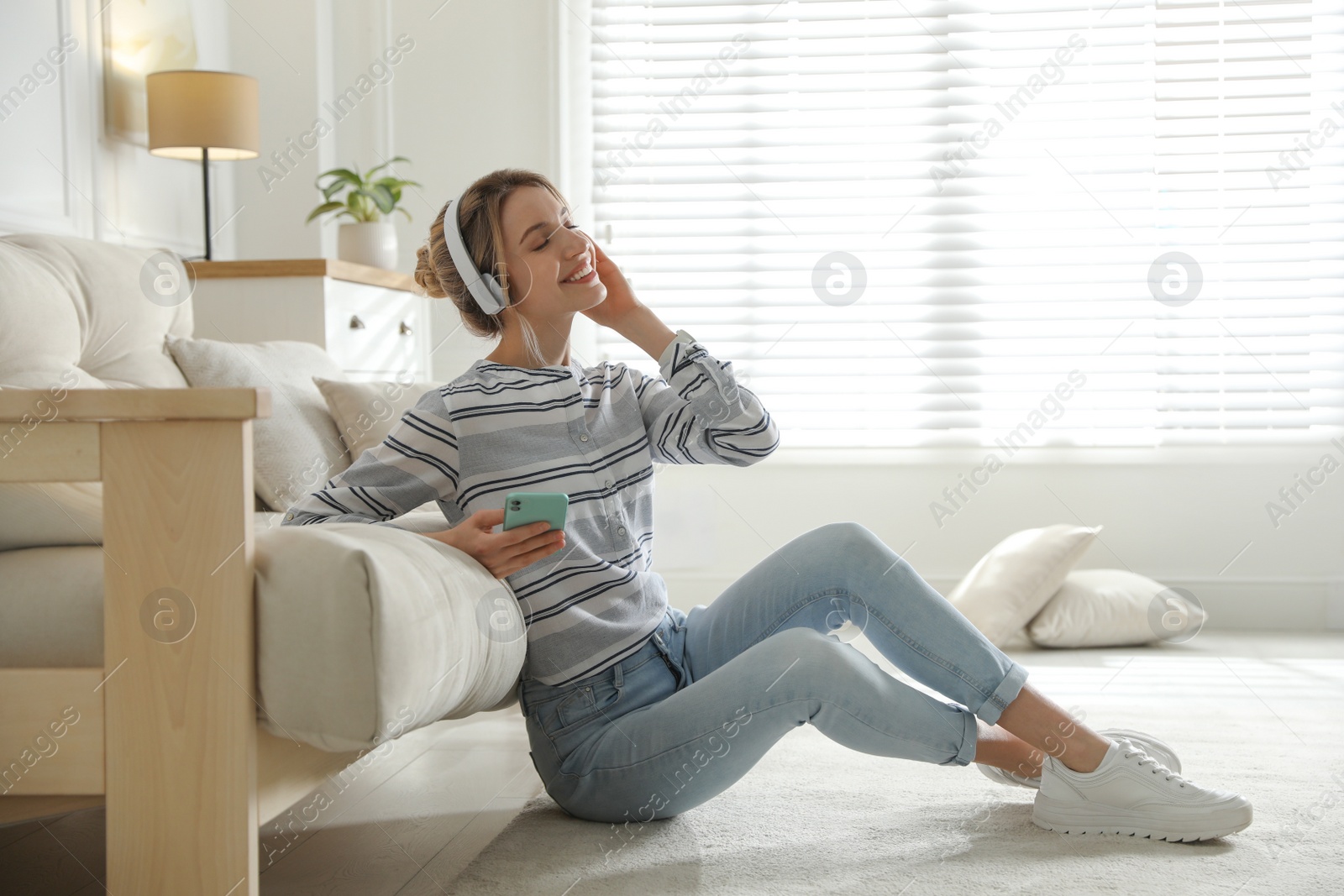 Photo of Young woman listening to music at home