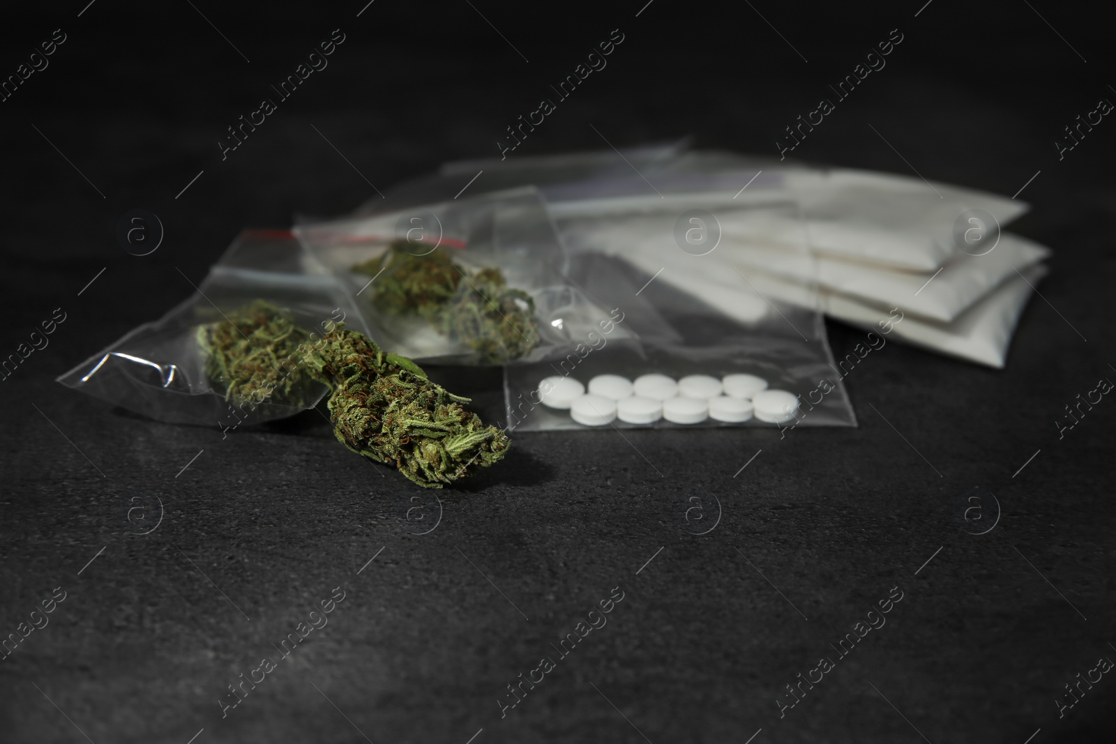 Photo of Cocaine, dried hemp and ecstasy on grey table. Space for text