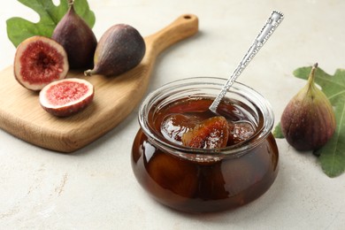 Photo of Jar of tasty sweet jam and fresh figs on white table