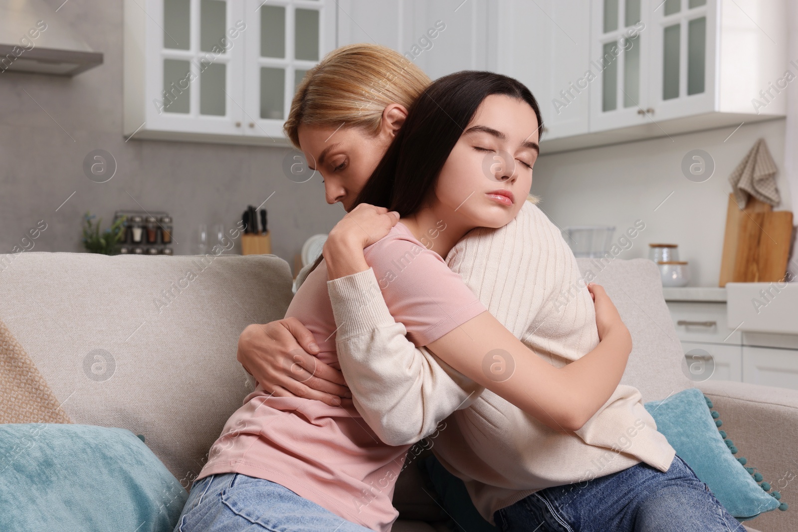 Photo of Mother consoling her upset daughter at home. Teenager problems