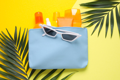 Photo of Flat lay composition with sun protection products on yellow background