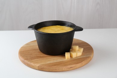 Photo of Fondue with tasty melted cheese on white table