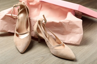 Photo of Pair of beautiful shoes and box on wooden background
