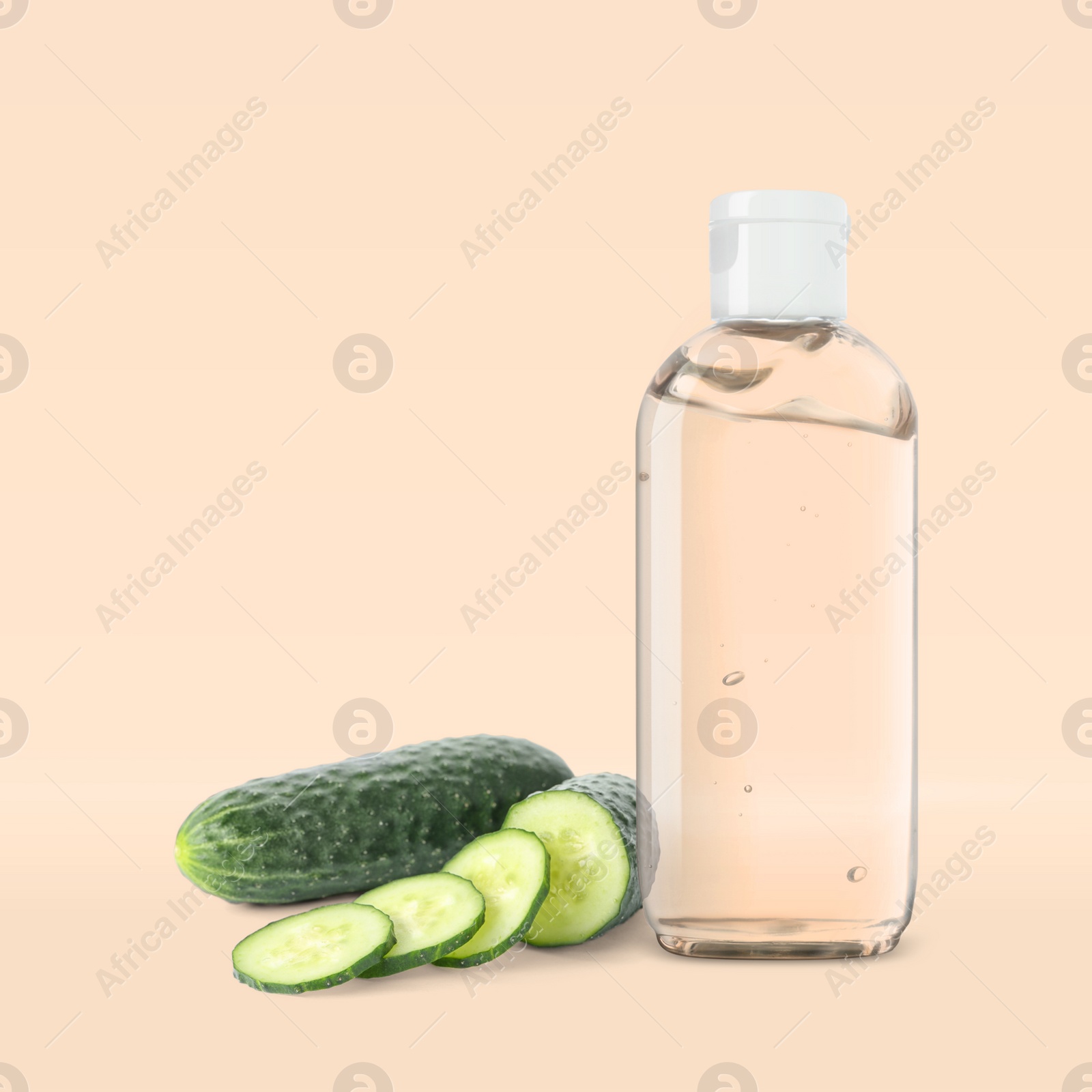 Image of Bottle of micellar cleansing water, fresh cucumbers on beige background. Makeup remover