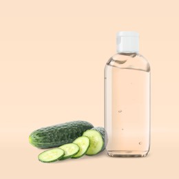 Image of Bottle of micellar cleansing water, fresh cucumbers on beige background. Makeup remover