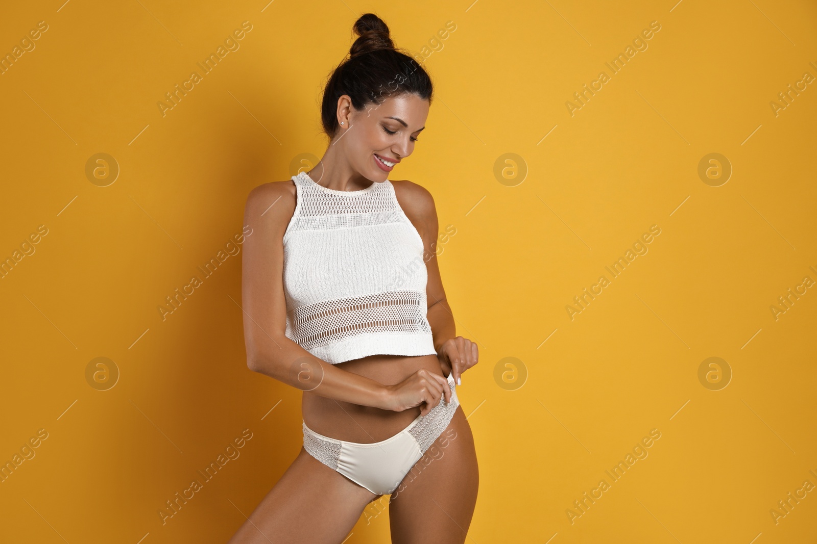 Photo of Beautiful woman in white sexy panties on yellow background