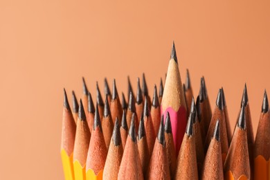 Many sharp graphite pencils on brown background, closeup. Space for text