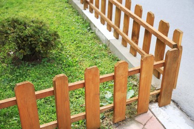 Photo of Small wooden fence on sunny day outdoors