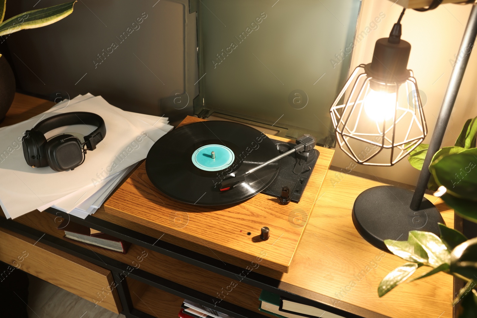 Photo of Stylish turntable with vinyl record on table indoors