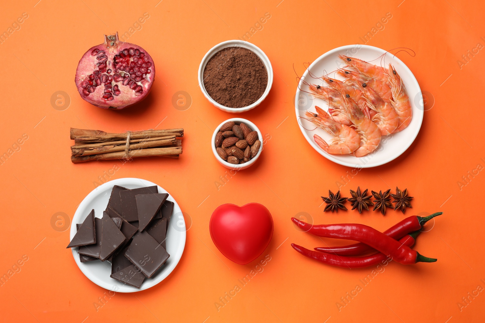 Photo of Natural aphrodisiac. Different products and heart model on orange background, flat lay