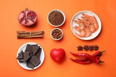 Photo of Natural aphrodisiac. Different products and heart model on orange background, flat lay