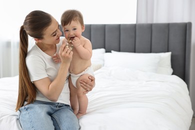 Photo of Mother with her baby on bed at home. Space for text