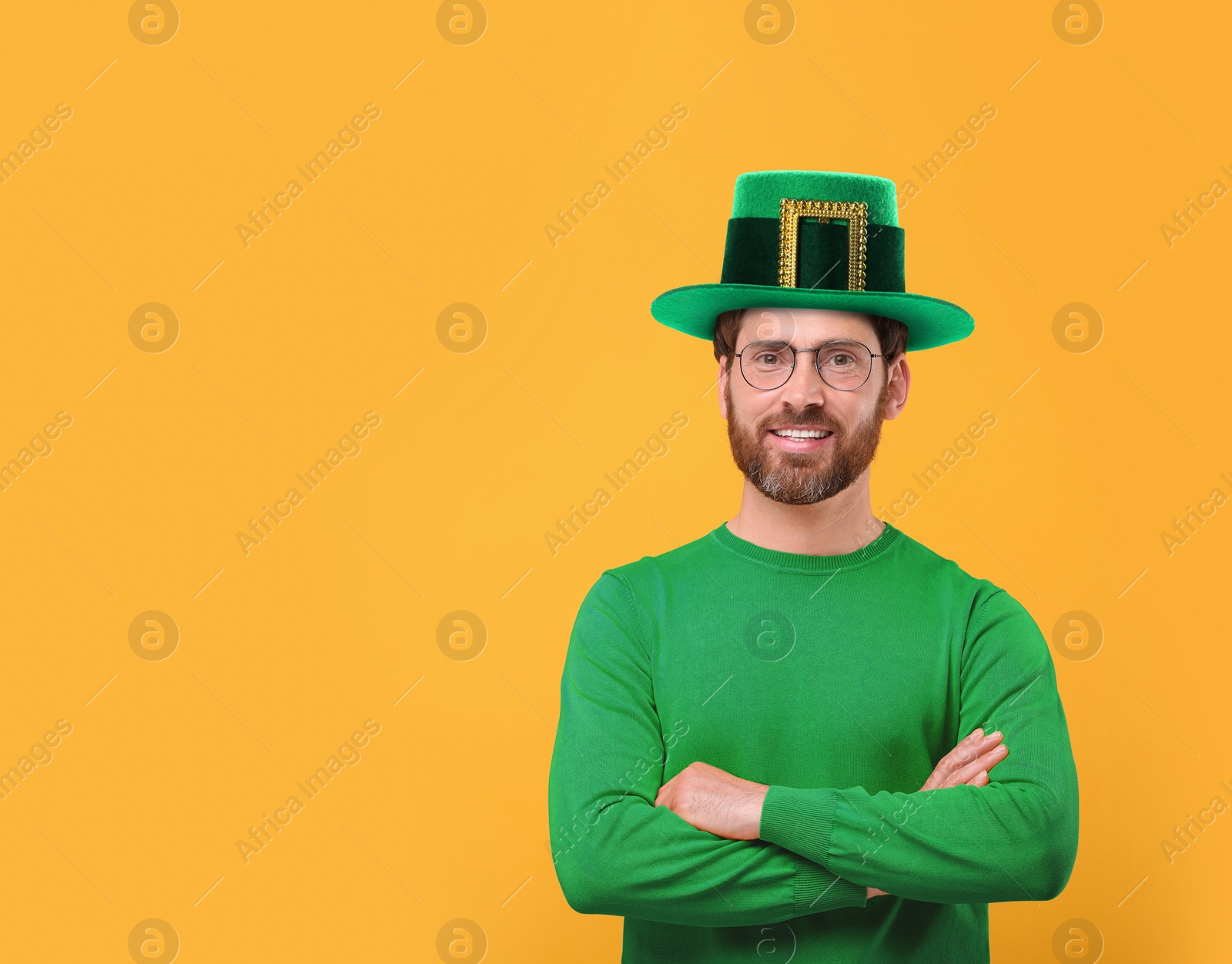 Image of St. Patrick's day party. Man in green leprechaun hat on golden background. Space for text