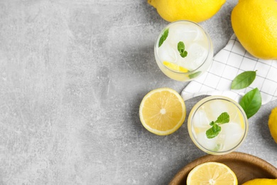 Photo of Cool freshly made lemonade and fruits on grey table, flat lay. Space for text