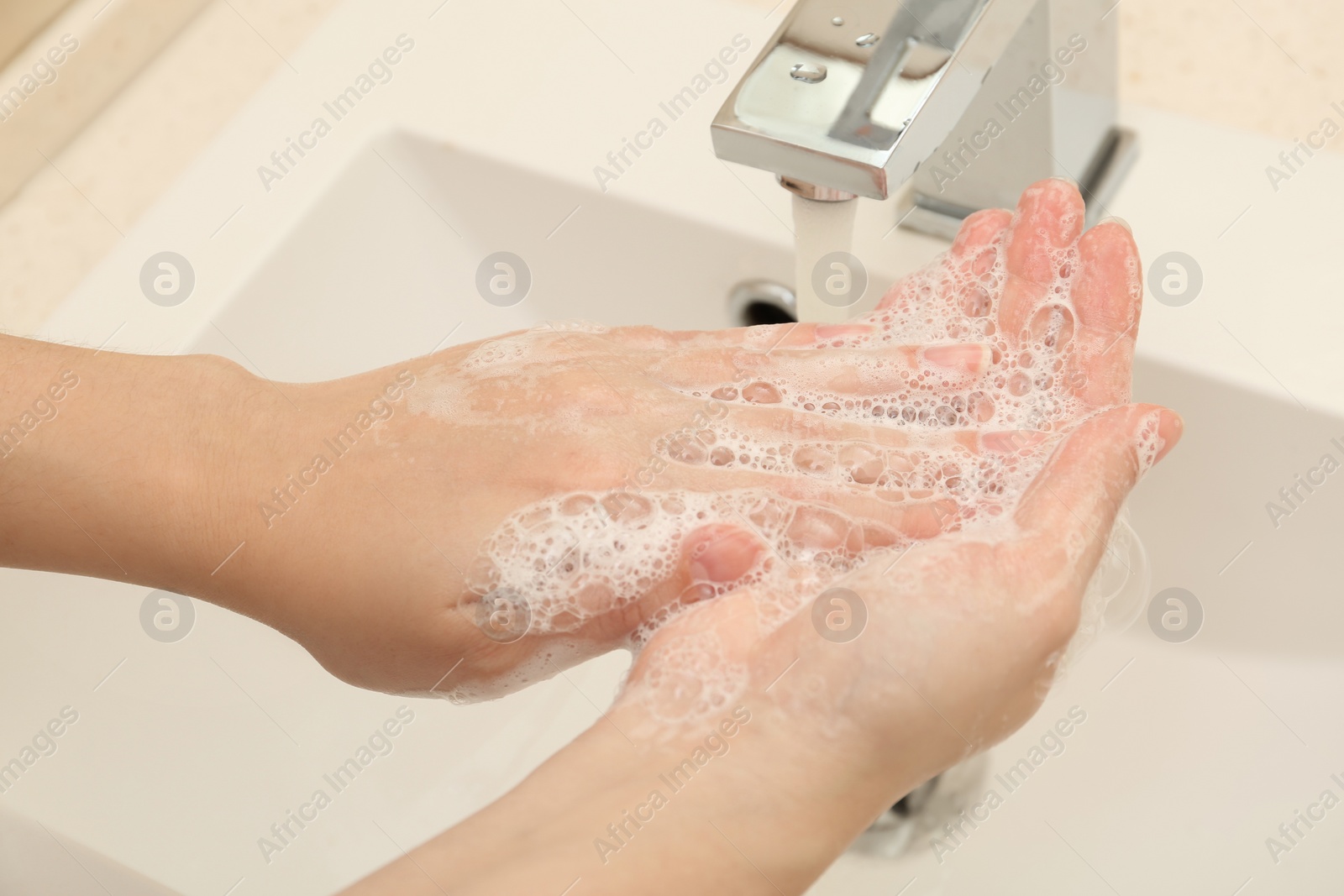 Photo of Woman washing hands with antiseptic soap in bathroom, closeup