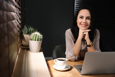 Beautiful mature woman working with laptop at home