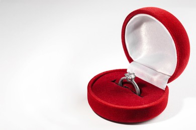 Photo of Beautiful engagement ring in red box on white background, space for text