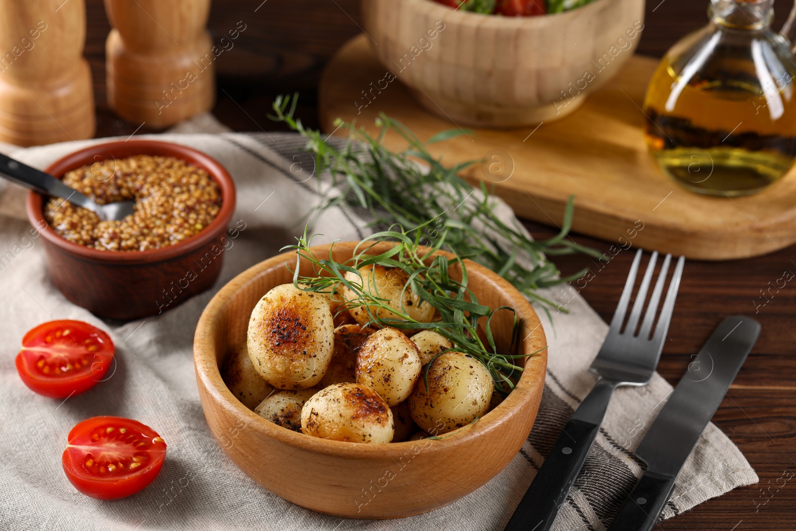 Photo of Delicious grilled potatoes with tarragon and mustard on wooden table