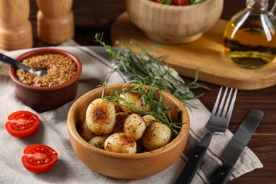 Delicious grilled potatoes with tarragon and mustard on wooden table