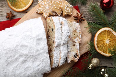 Traditional Christmas Stollen with icing sugar on wooden table, flat lay