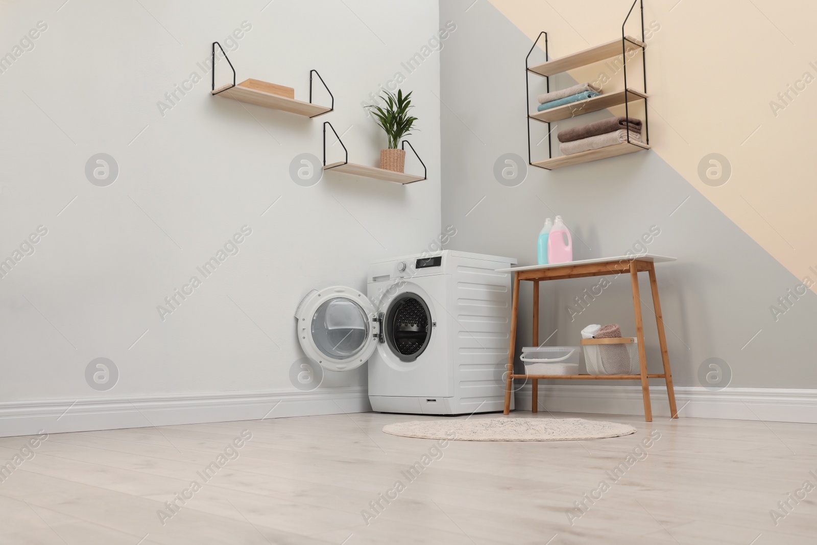 Photo of Modern washing machine in laundry room interior