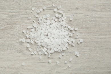 Natural sea salt on light wooden table, flat lay