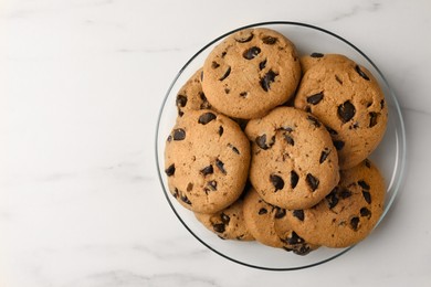 Photo of Delicious chocolate chip cookies on white marble table, top view. Space for text