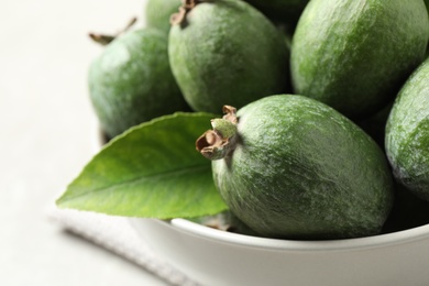 Photo of Delicious fresh feijoas in bowl on table, closeup