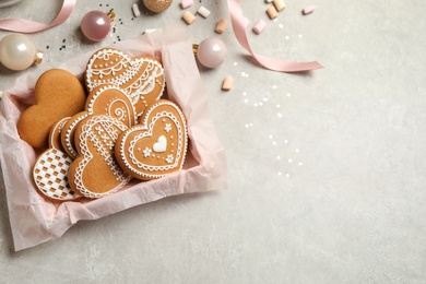 Photo of Tasty heart shaped gingerbread cookies and festive decor on light table. Space for text