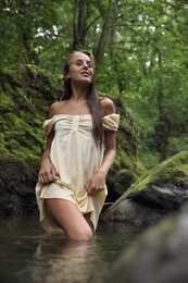 Photo of Beautiful young woman in mountain river in forest