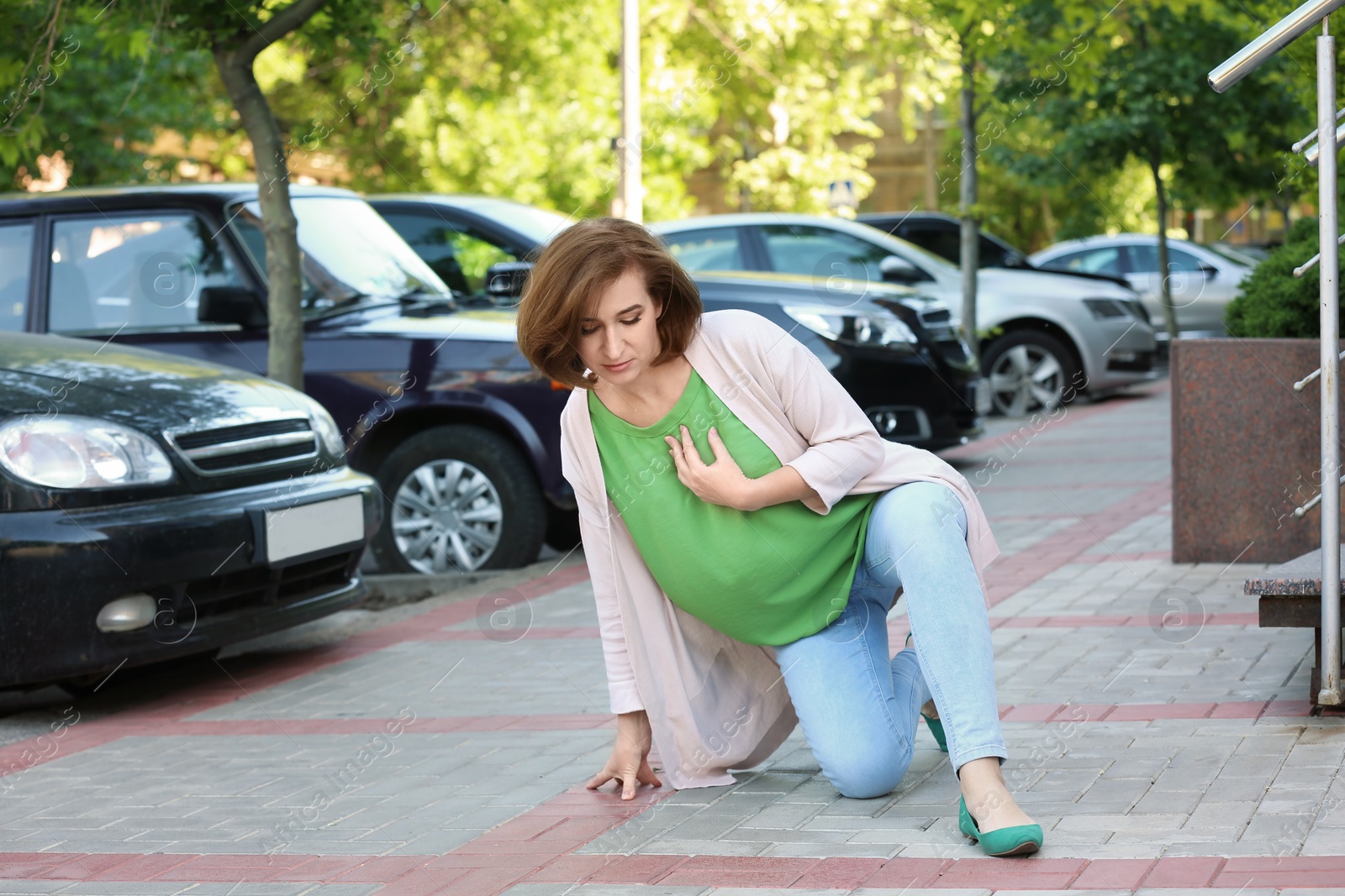 Photo of Mature woman having heart attack, outdoors